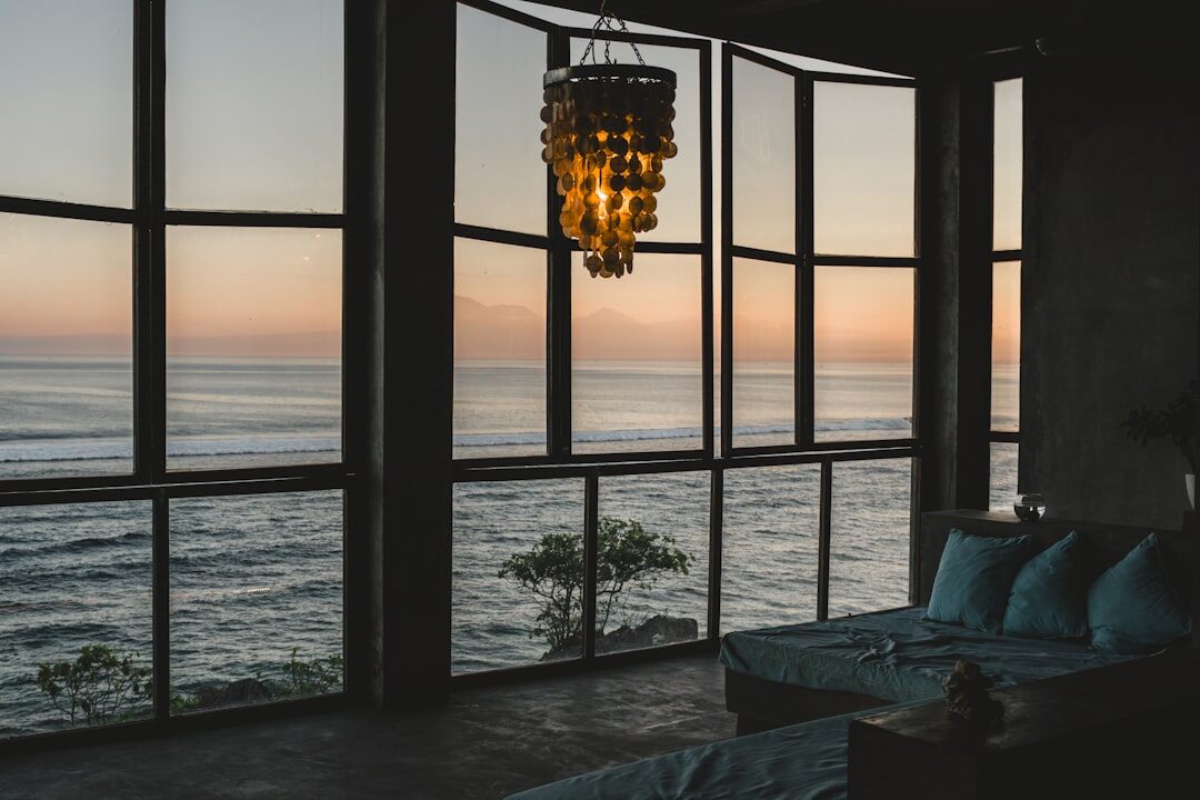 Modern minimalist oceanfront villa with large glass walls and a stone facade